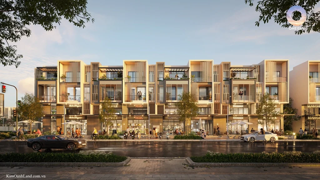 Dãy Nhà phố One Era Thuận An xây sẵn rực rỡ cây xanh với kiến trúc modern tropical, ban công có cây leo cascading rủ xuống, vỉa hè rộng lát đá có cây cổ thụ dọc con đường nội bộ sạch đẹp dưới nắng vàng kim 2026 tại 1era.vn.